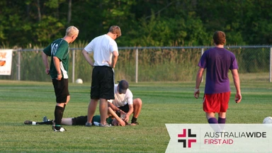 A soccer player lying on the floor with a head injury